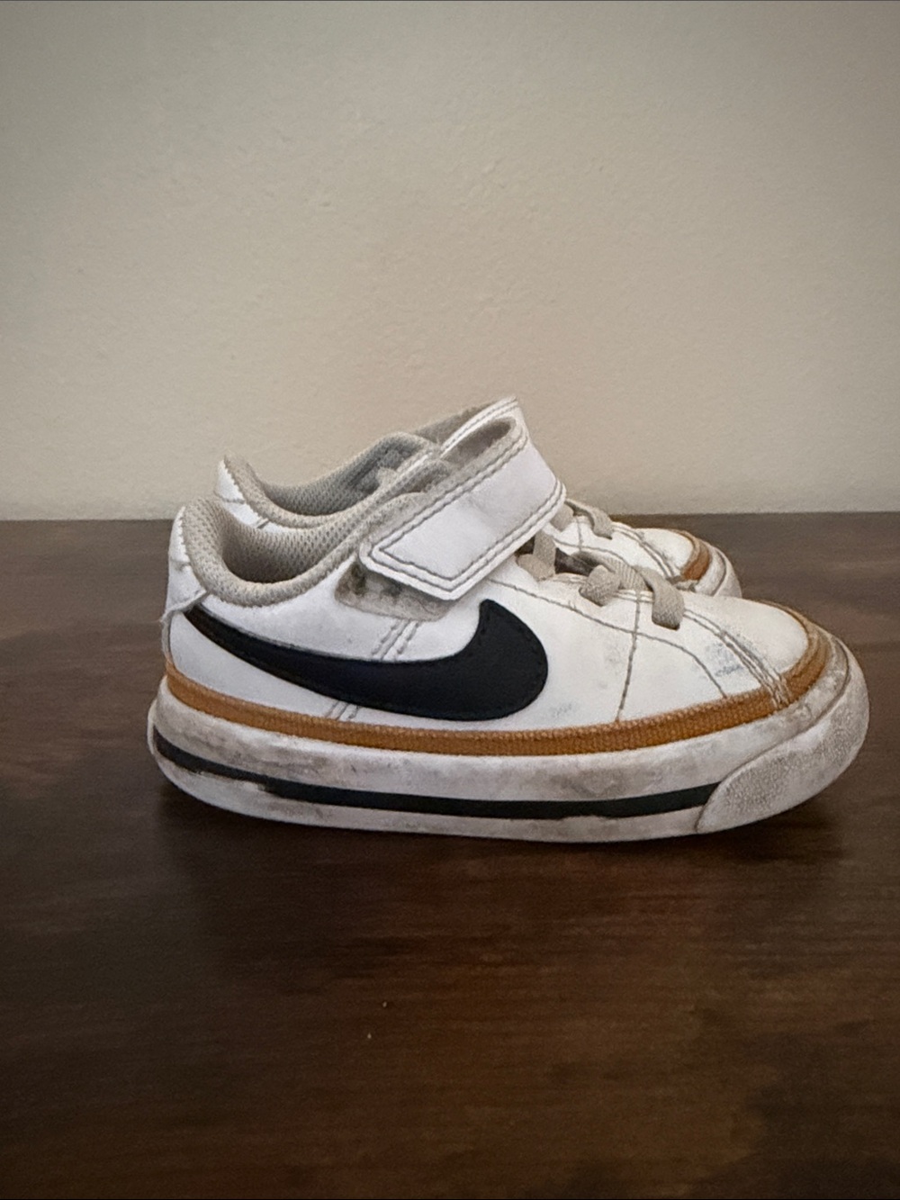 Nike Kids White Sneaker with Black Swoosh and Gold Trim